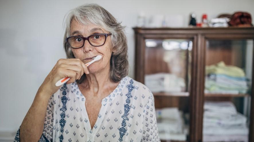 Senior woman brushing her teeth.