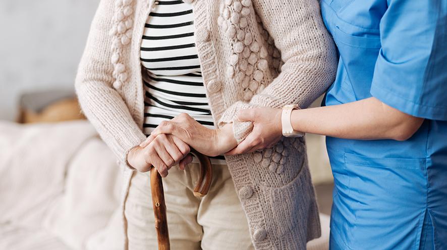 Senior woman being helped by nurse.