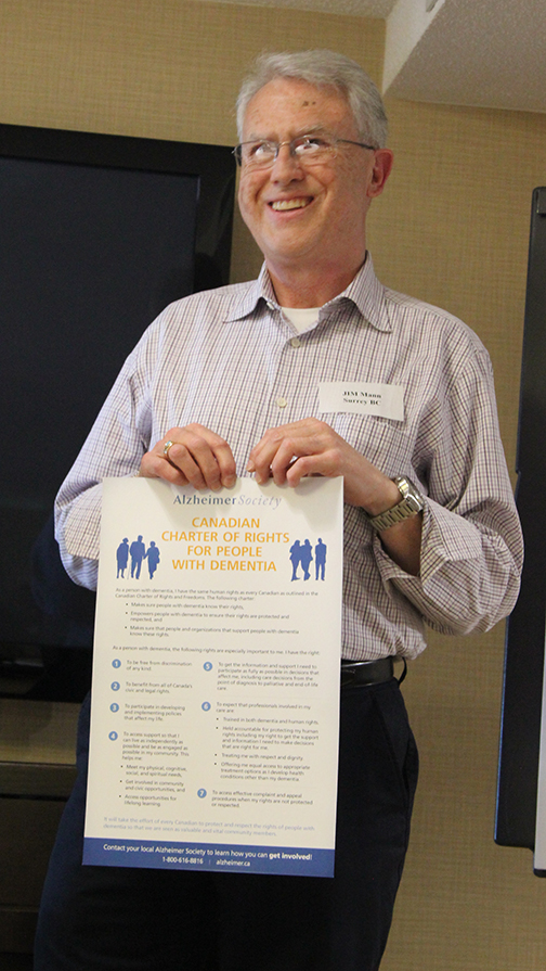 Jim Mann holding the Canadian Charter of Rights for People with Dementia.