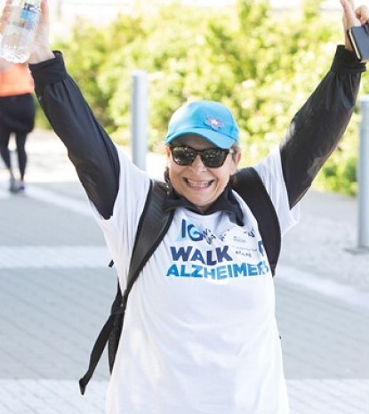 Woman at the IG Wealth Management Walk for Alzheimer's raising her hands in joy.