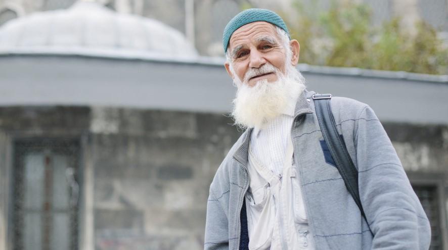 Senior man in front of mosque.