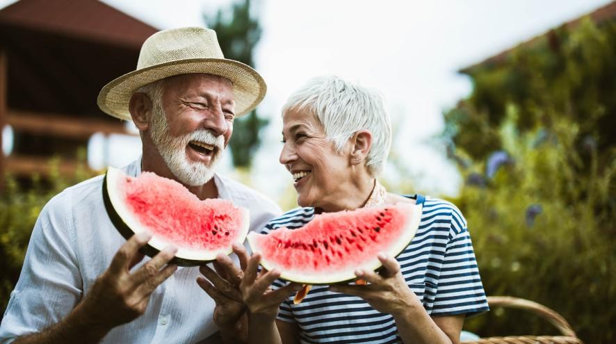 Senior couple eating a watermelon together.