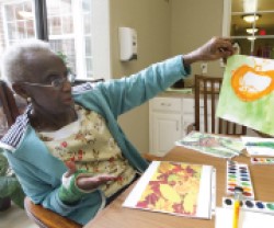 Senior woman holding her painting.