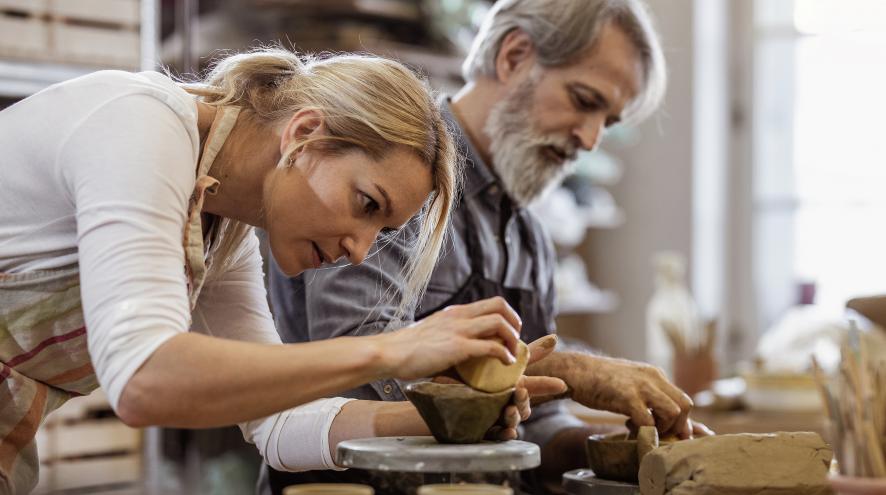 Two people in a pottery class.