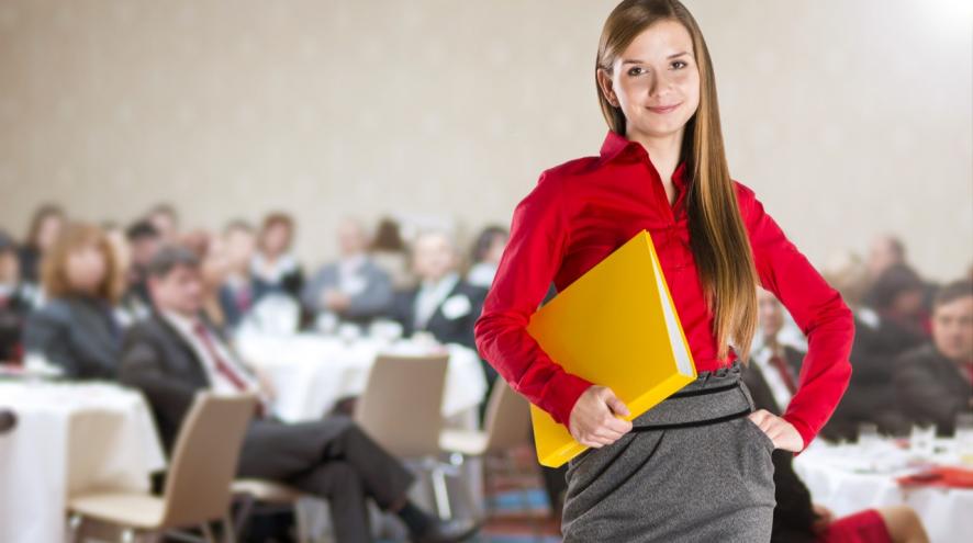 Young woman holding a file folder at a conference.