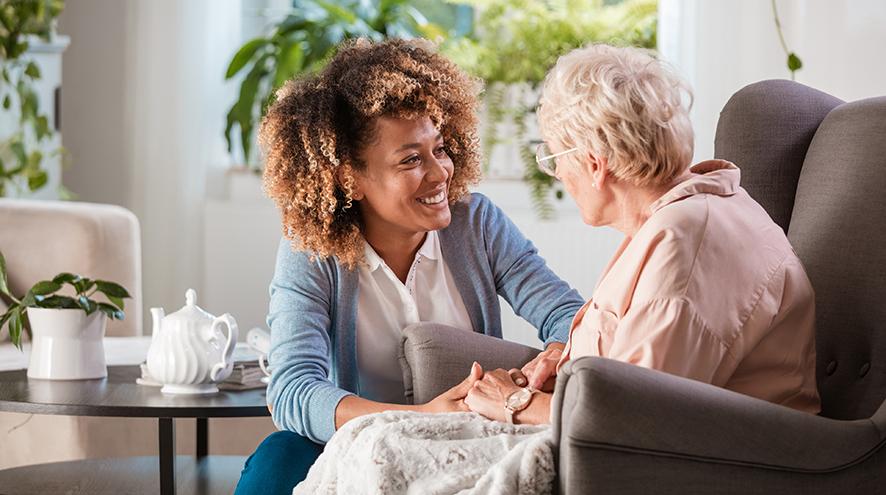 Friendly healthcare worker talking to a senior client.