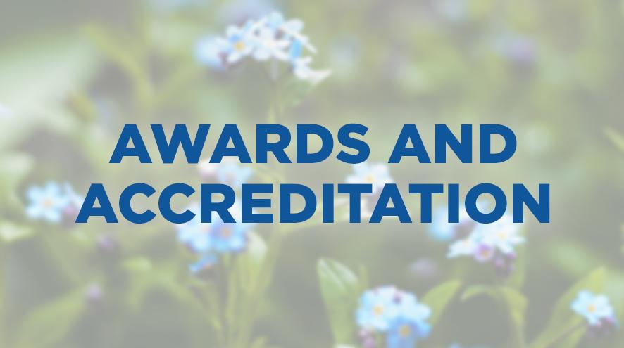 An image of Forget-Me-Not flowers in the background that says Awards and Accreditation