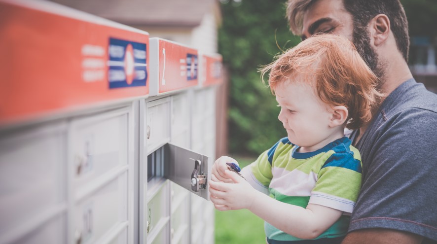Father and child sending a letter at the mailbox.
