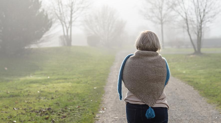 Senior woman walking in the fog.