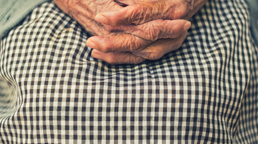 Image of a senior holding her hands in her lap.